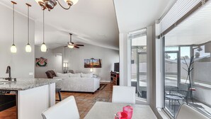 Une cuisine moderne avec un coin repas, une grande fenêtre et un ventilateur de plafond.