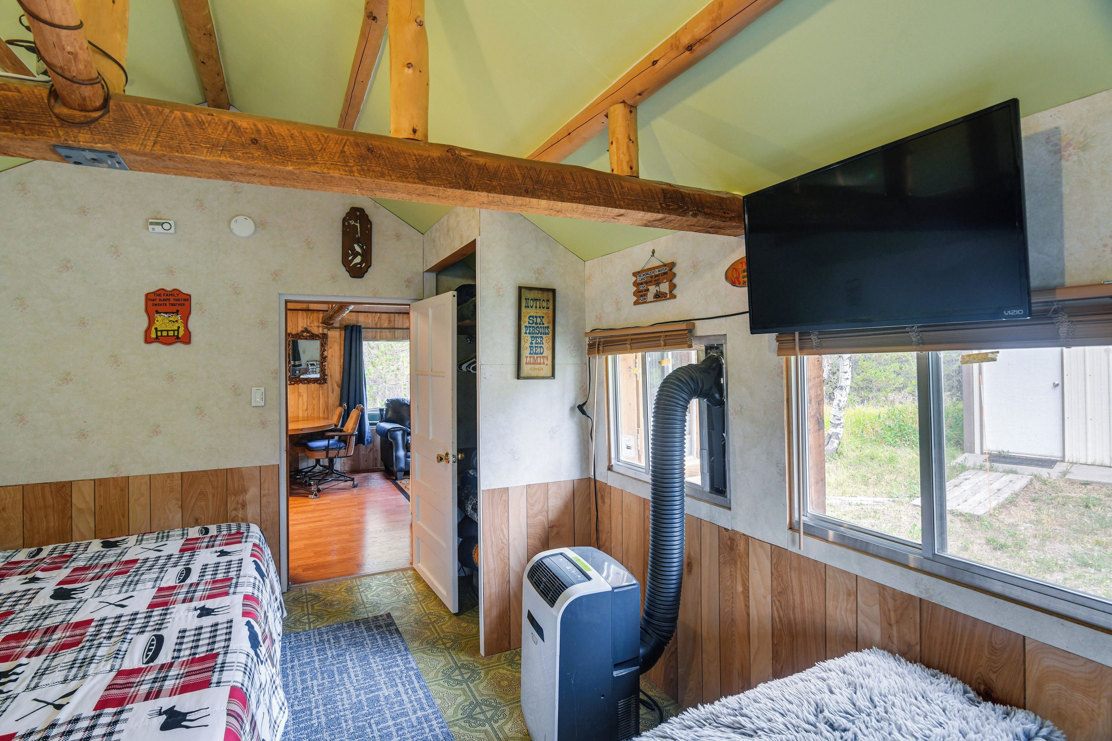 A room with a bed, a desk, a chair, a television, and a window.