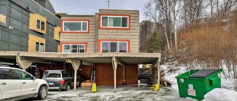 A multi-story building with a garage and a covered parking area.