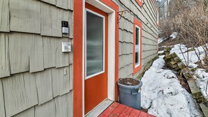 Une maison avec une porte rouge, une fenêtre et une boîte aux lettres.