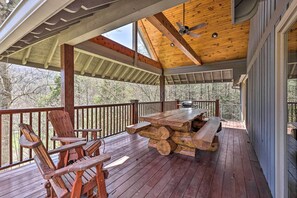 A wooden deck with a table and chairs, a ceiling fan, and a view of trees. - 40-acre Mtn-view Retreat w/ Hot Tub in Banner Elk! (Banner Elk)