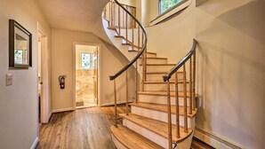 A spiral staircase with wooden steps and metal railings, leading to an upper floor.