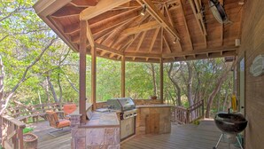 An outdoor deck with a stone fireplace, a grill, and a seating area. - Lake Granbury Getaway! Family Home w/ Deck & Games (Granbury)