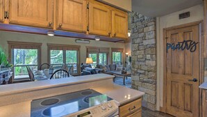A kitchen with wooden cabinets, a stone wall, and a sign that reads "pantry." - Lake Granbury Getaway! Family Home w/ Deck & Games (Granbury)