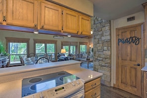 A kitchen with wooden cabinets, a stone wall, and a 'pantry' sign. - Lake Granbury Getaway! Family Home w/ Deck & Games (Granbury)