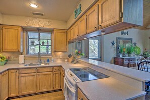 A kitchen with wooden cabinets, a built-in stove, and a large island. - Lake Granbury Getaway! Family Home w/ Deck & Games (Granbury)