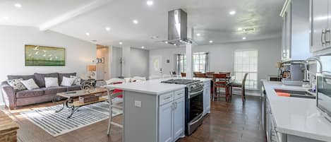 Uma sala ampla com sofá, mesa de centro e mesa de jantar com cadeiras.