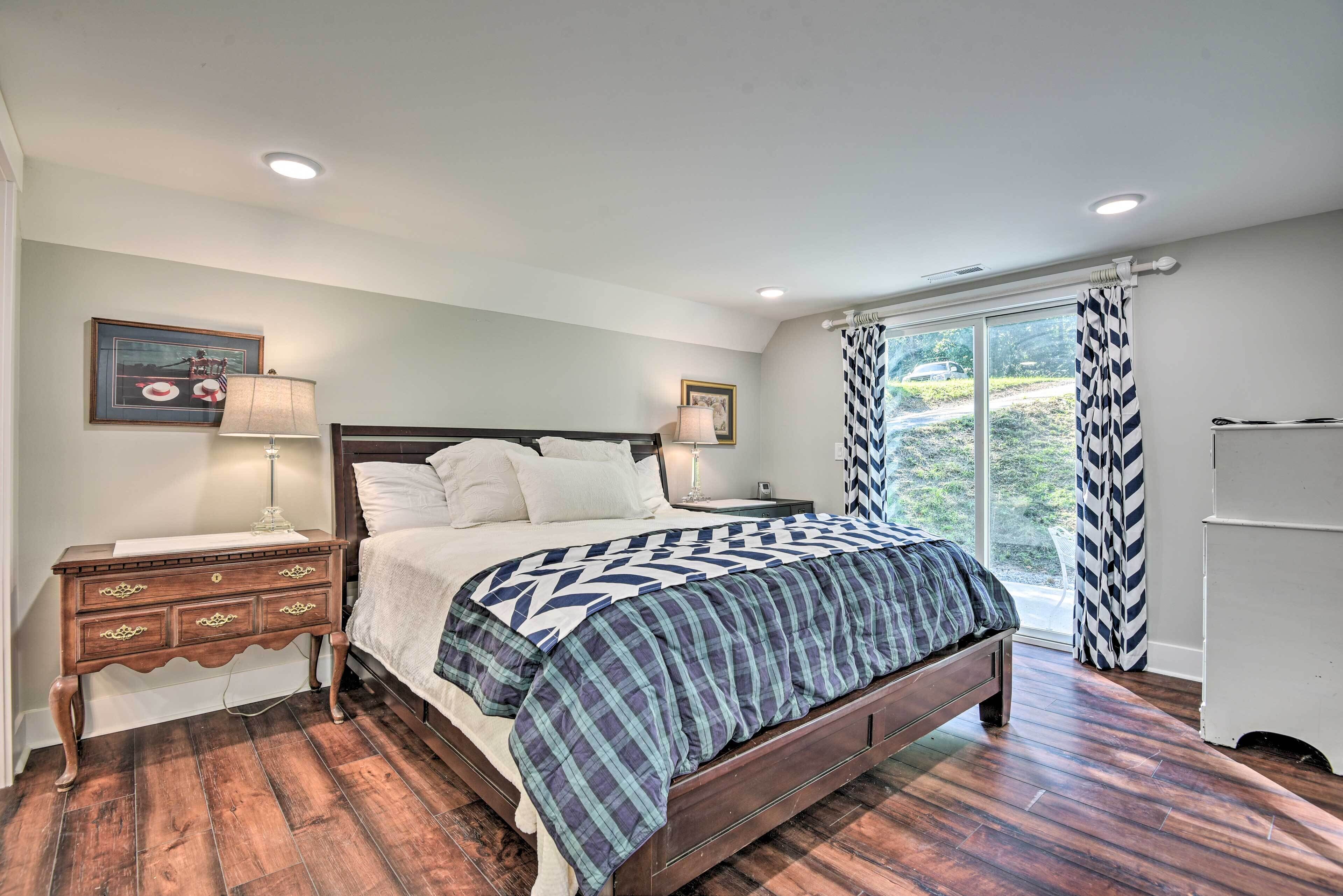 A bedroom with a large bed, wooden nightstands, and a window with curtains.