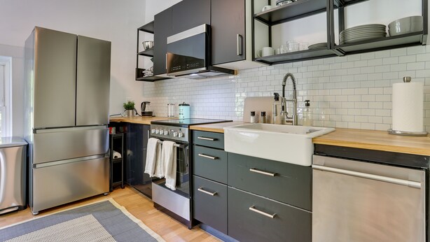 A modern kitchen with stainless steel appliances, a built-in oven, and a wooden countertop. - Quaint Goshen Apartment w/ Patio! (Goshen)