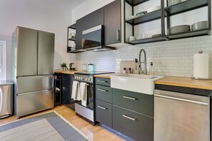 Una cocina moderna con electrodomésticos de acero inoxidable, horno empotrado y encimera de madera.