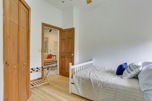 Une chambre avec une armoire en bois, un lit avec des oreillers et une petite table avec une chaise.