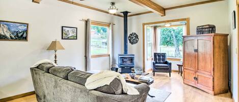 A cozy living room with a sofa, a wooden cabinet, a fireplace, and a ceiling fan.