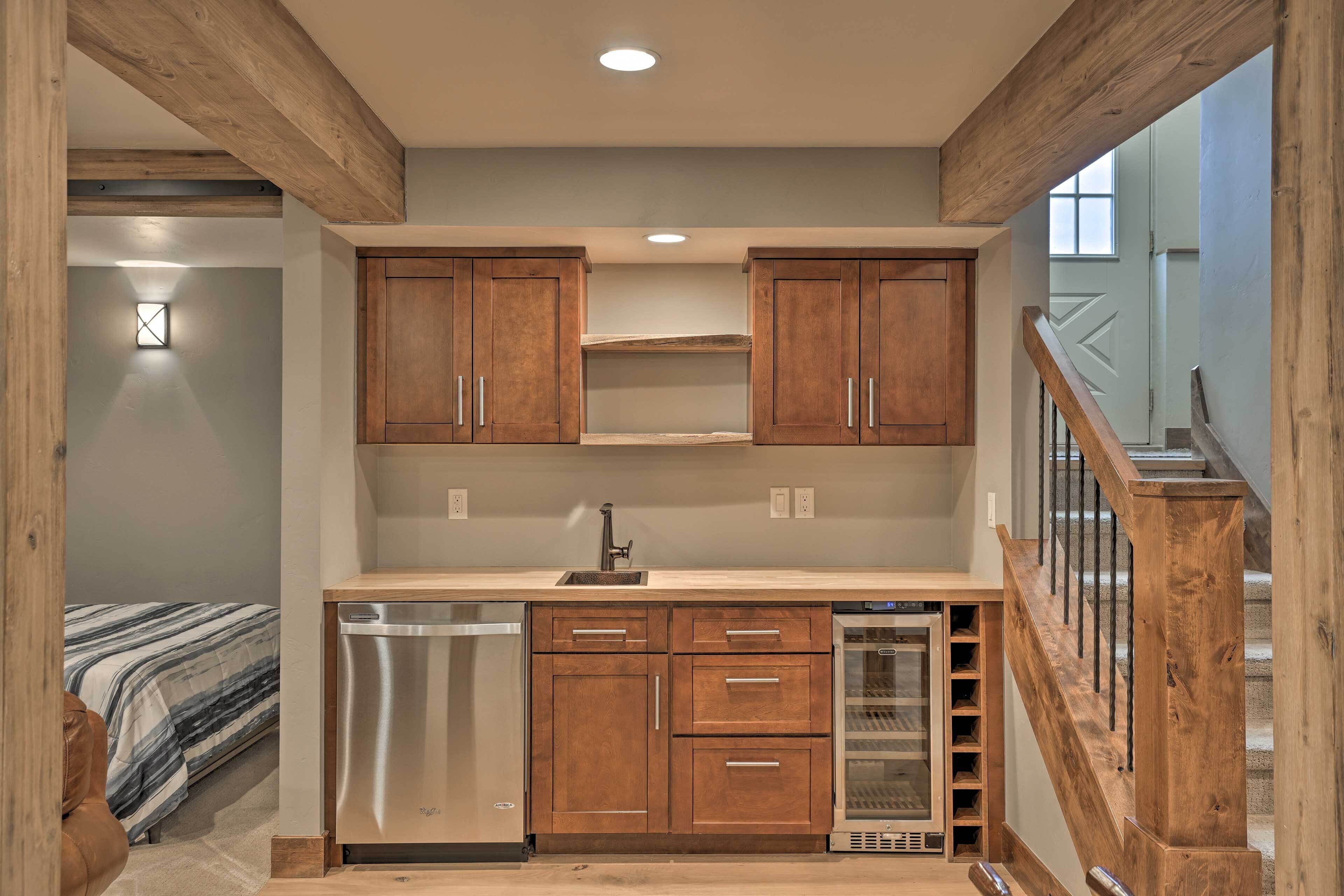 A compact kitchen with wooden cabinets, a dishwasher, and a wine cooler.