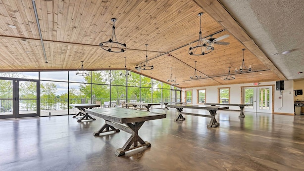 Un vaste espace intérieur doté de hauts plafonds, de grandes fenêtres et de nombreuses tables.