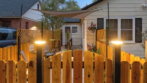 A wooden fence with a welcome sign, a house with a white exterior, and a car parked nearby. - Ski & Hike: Cozy Dtwn Reno Studio w/ Fireplace (Reno)