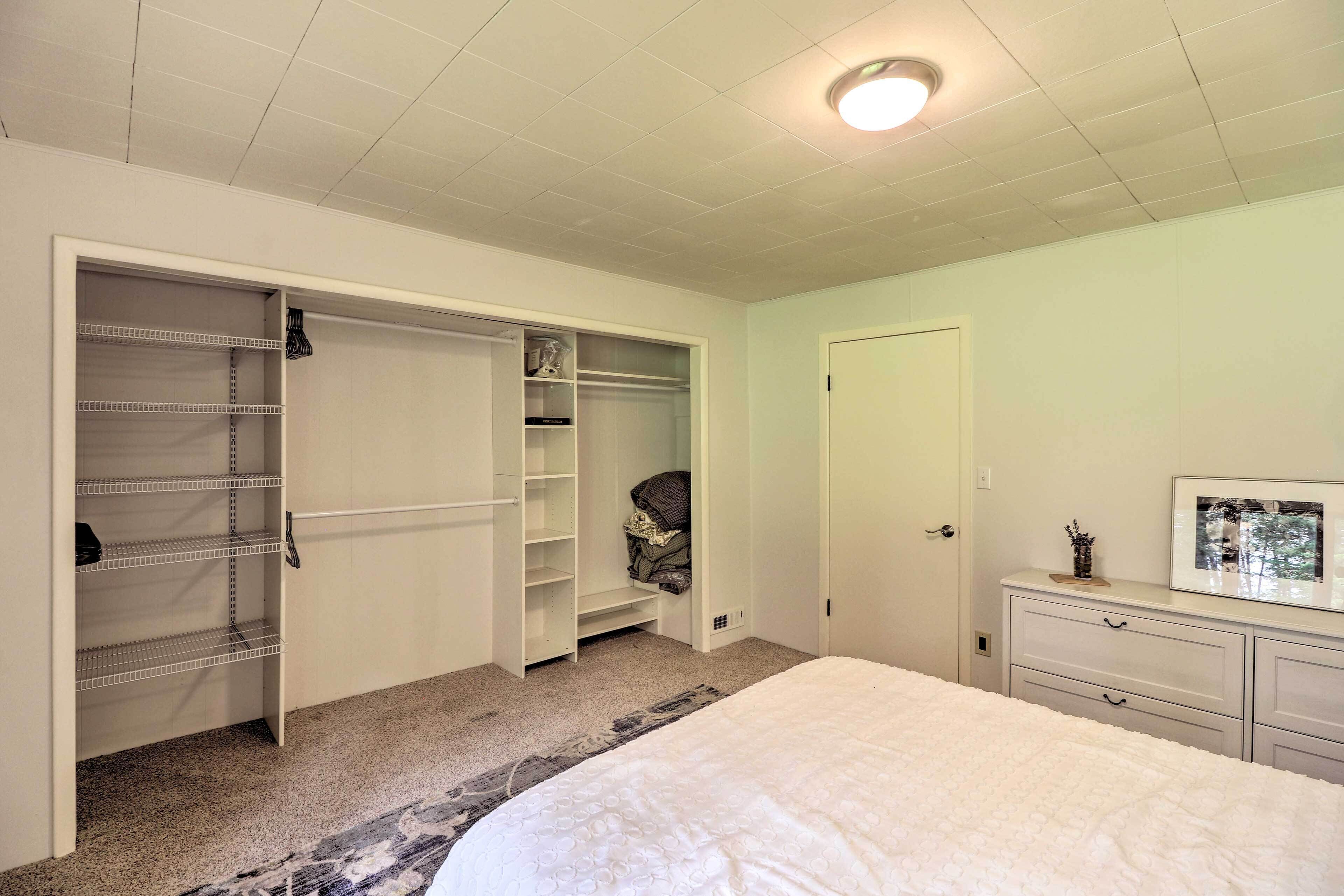 Un dormitorio con una cama grande, un vestidor y un aparador.