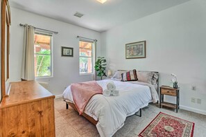 Une chambre à coucher avec un lit, une table de chevet et une commode en bois.