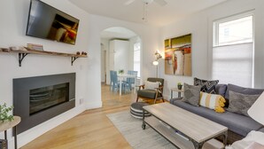 Ein modernes Wohnzimmer mit Flachbildfernseher, Kamin, Sofa und Essbereich.