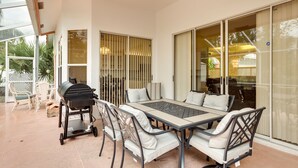 An outdoor patio with a grill, dining table, and chairs. - Port St Lucie Home ~ 3 Mi to Botanical Gardens! (Port Saint Lucie)