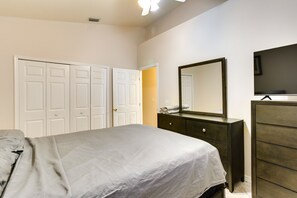 A bedroom with a bed, a dresser, a mirror, and a wardrobe.