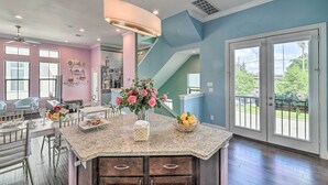 A spacious kitchen with a granite countertop, a dining area with chairs, and a view of the outdoors through large windows. - Chic Midtown House ~ 2 Mi to Dtwn Houston! (Houston)