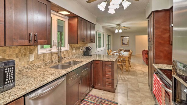 A kitchen with granite countertops, stainless steel appliances, and wooden cabinets. - Norfork Getaway: Walk in White River Access! (Norfork)