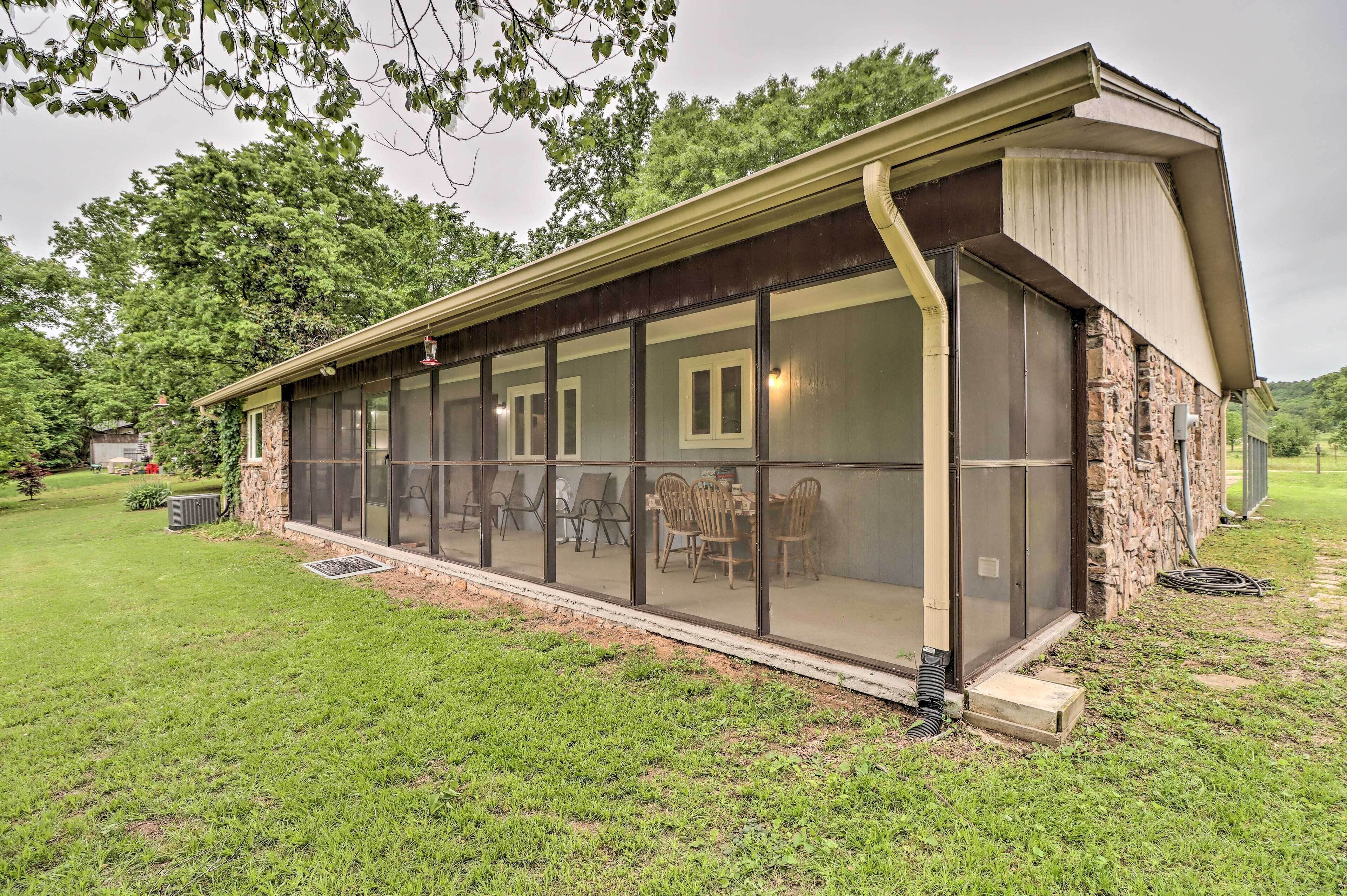 A long, covered outdoor dining area with a stone exterior and large windows.