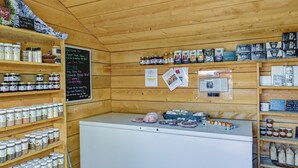A rustic wooden interior with shelves of jars and a white refrigerator. - Upstate New York Vacation Rental Near Cooperstown! (Jordanville)