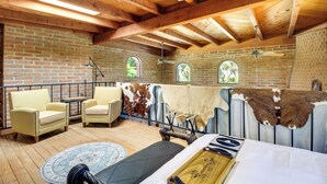A rustic room with wooden beams, brick walls, and leather furniture. - Eclectic Tucson Home 2 Mi to Saguaro National Park (Tucson)