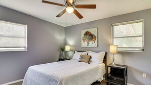 A bedroom with a bed, two bedside tables with lamps, a ceiling fan, and a wall-mounted artwork. - Orlando Health Access Pet-friendly Lakeland Gem (Lakeland)