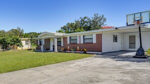 A single-story house with a front yard, a basketball hoop, and a garage. - Orlando Health Access Pet-friendly Lakeland Gem (Lakeland)