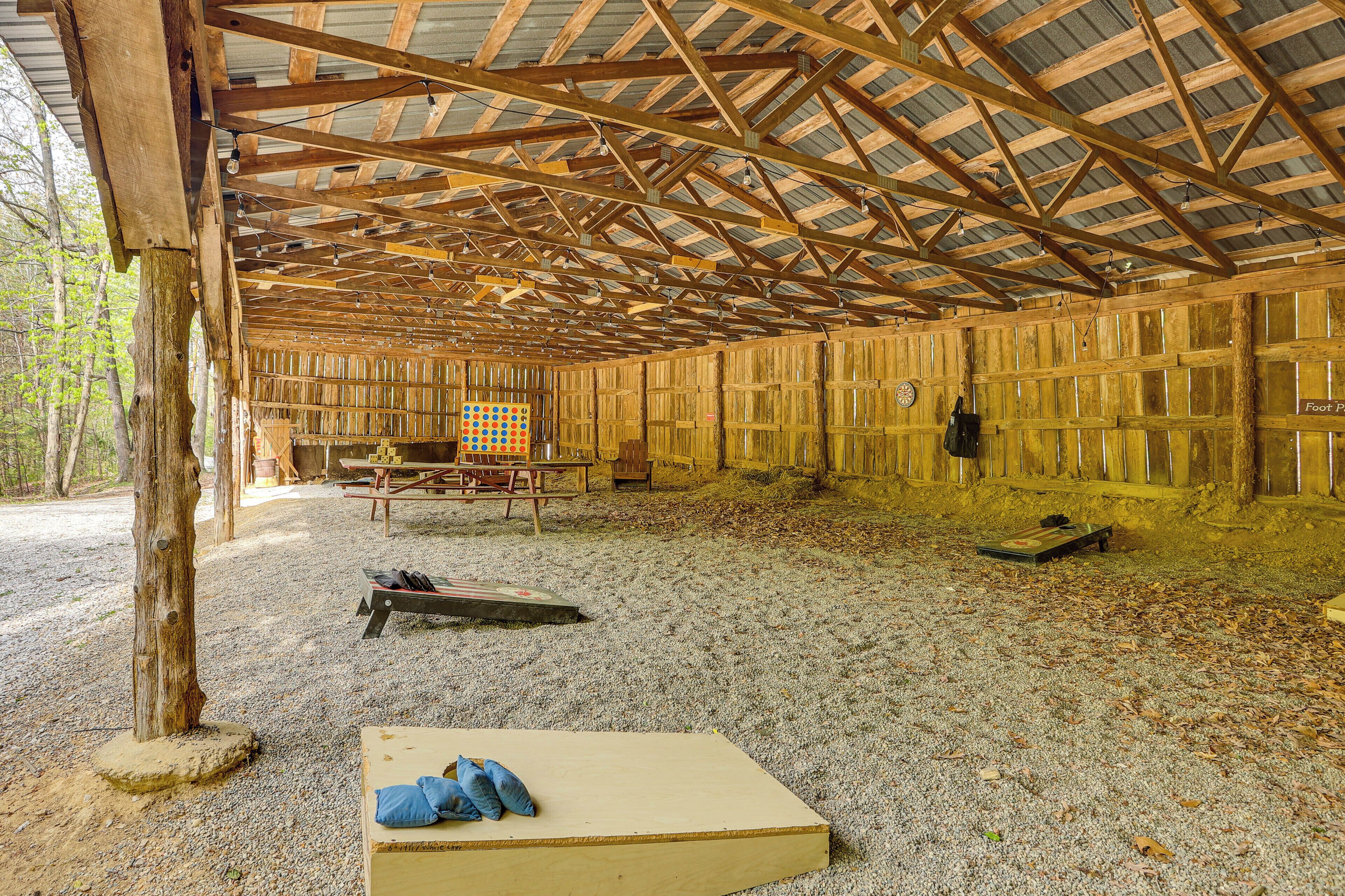 A covered outdoor shooting range with wooden structures, a target, and shooting equipment.