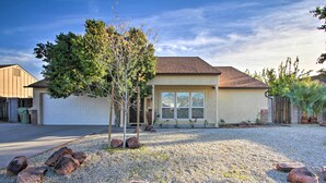 A residential house with a garage, a small tree, and a gravel driveway. - Glendale Oasis w/ Fenced Yard & Private Pool! (Glendale)