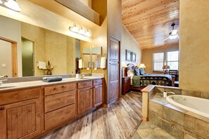 A spacious bathroom with a large wooden vanity, a freestanding bathtub, and a large mirror. - Luxe Resort Cabin w/ Deck: Hike, Swim, Relax! (Show Low)
