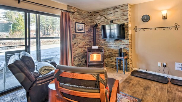 A cozy living room with a fireplace, leather sofa, and a TV. - Walk to Ski Lift & Village: Lovely Kirkwood Condo! (Kirkwood)