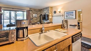 A modern kitchen with a built-in oven, coffee maker, and a sink. - Walk to Ski Lift & Village: Lovely Kirkwood Condo! (Kirkwood)