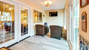 A hallway with wicker chairs, a television, and a sign that reads "Get your kicks route".