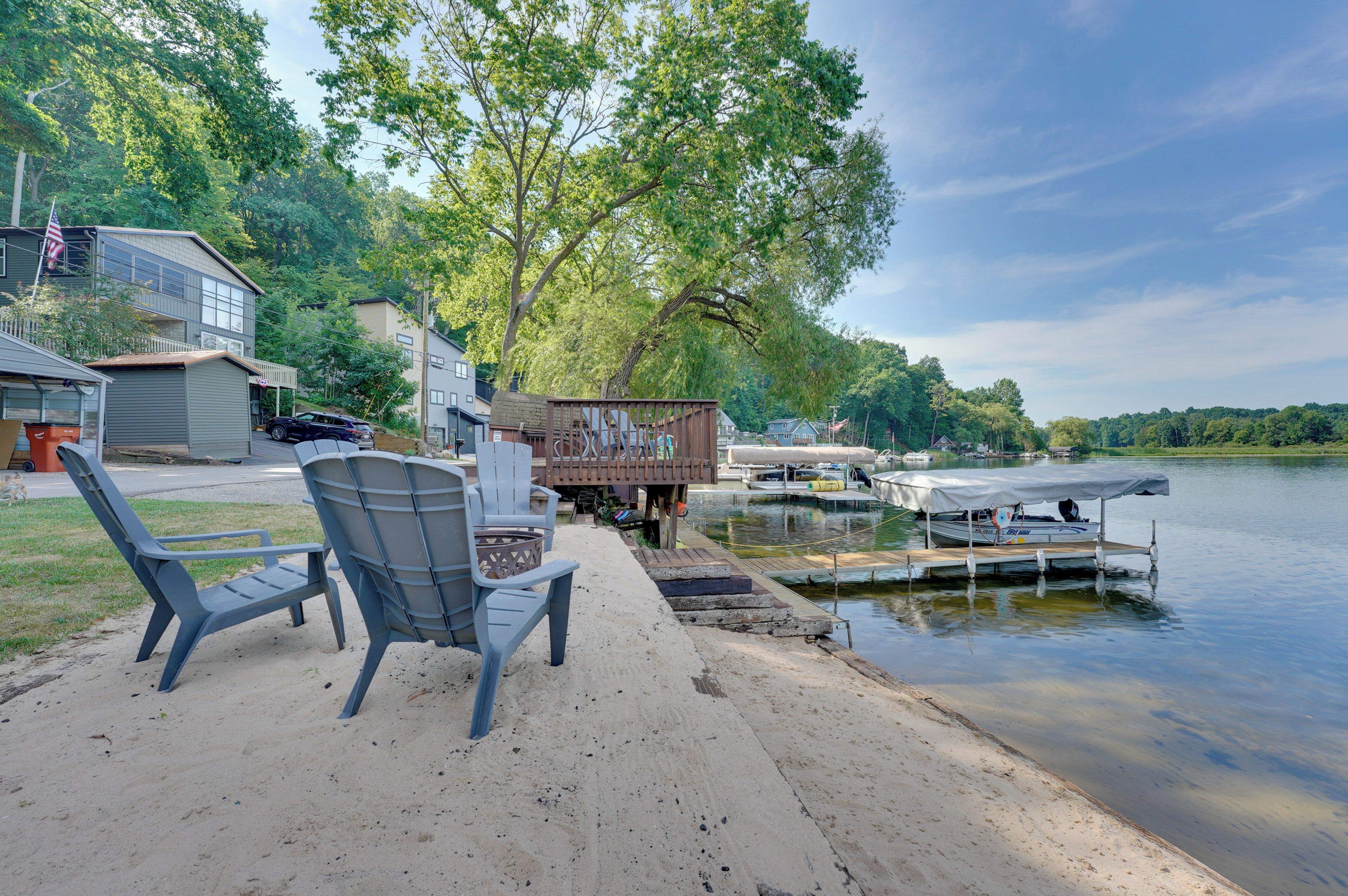 A lakeside property with a dock, a boat, and a row of houses.