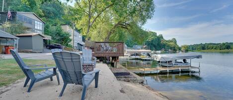 A lakeside property with a dock, a boat, and a row of houses.