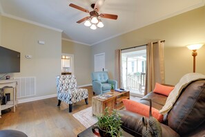 A living room with a ceiling fan, a television, a sofa, a coffee table, and a plant. - Sweet Southern Pines Abode w/ Yard & Covered Porch (Southern Pines)