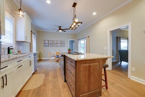 A kitchen with a wooden island, white cabinets, a ceiling fan, and recessed lighting. - Sweet Southern Pines Abode w/ Yard & Covered Porch (Southern Pines)