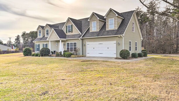 A two-story house with a garage, a front lawn, and a driveway. - Stokesdale Vacation Rental w/ Game Room! (Stokesdale)
