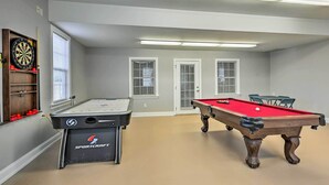 A pool table with a red felt top, a dartboard, and a billiards table with a SPORTCRAFT logo. - Stokesdale Vacation Rental w/ Game Room! (Stokesdale)