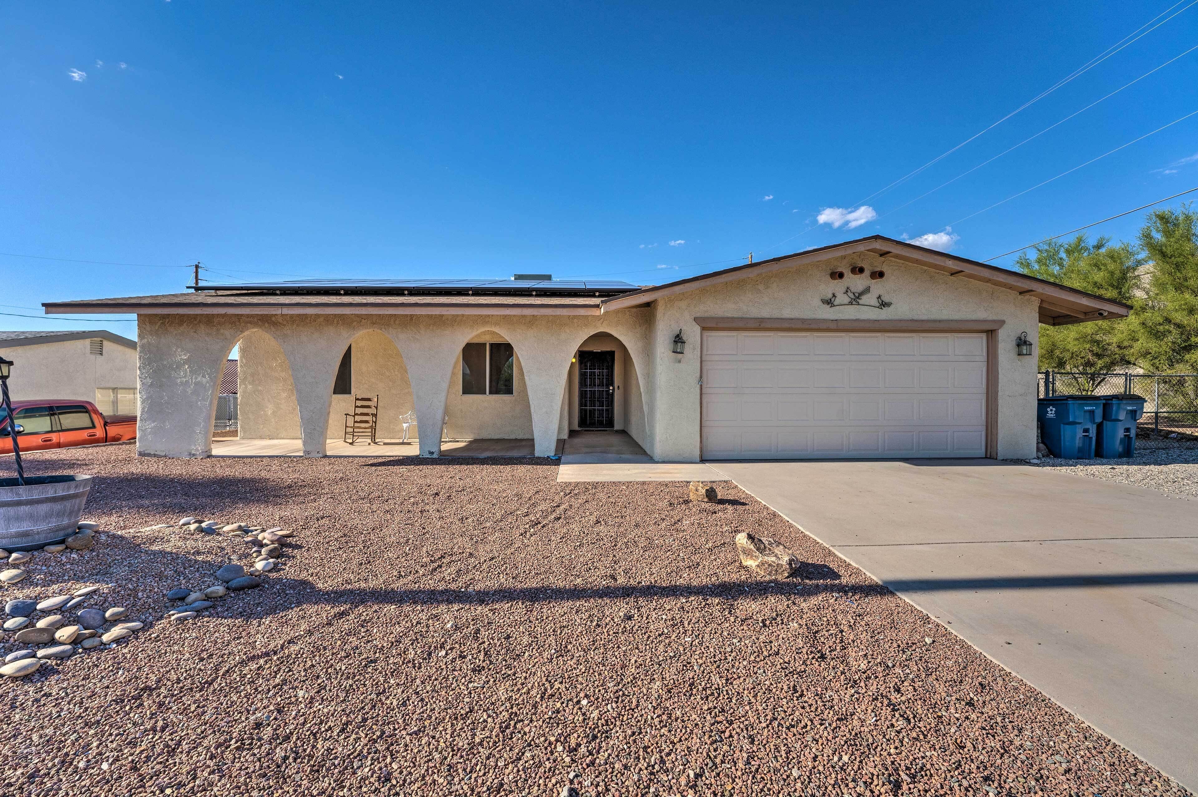 A single-story house with a garage, a driveway, and a gravel area with rocks.