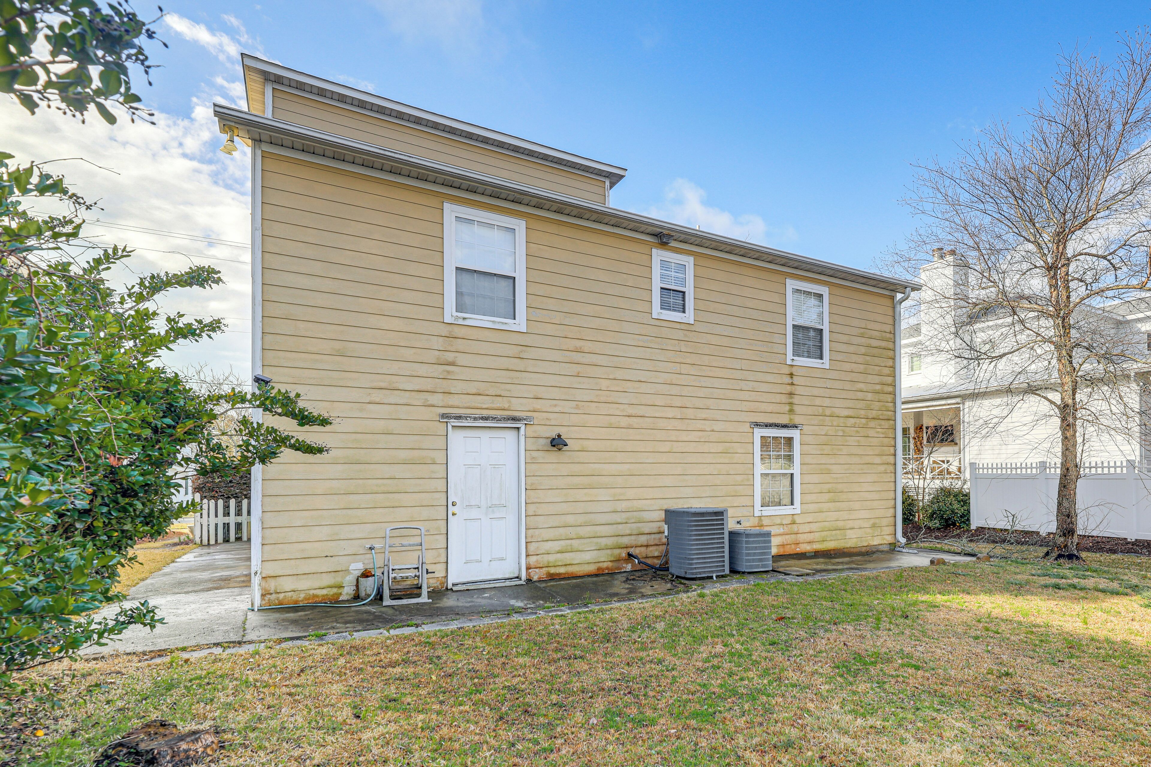 A two-story building with a front door, two windows, and a small porch area.