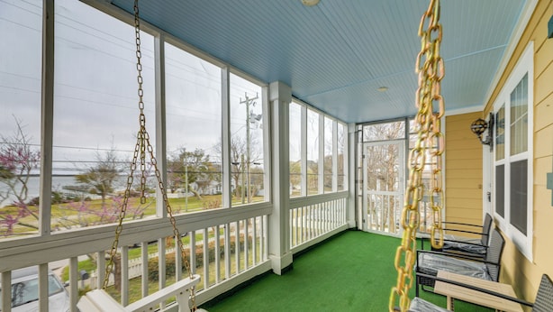 A covered porch with a swing, a bench, and a table with chairs. - Beach, Pier Access! Pet-friendly Crystal Coast Gem (Morehead City)