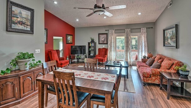 A spacious living room with a dining area, a red accent wall, and a ceiling fan. - Mt Juliet Getaway w/ Yard: 22 Mi to Nashville (Mount Juliet)