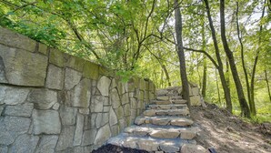 A stone staircase leading up a hill, surrounded by trees and greenery.
