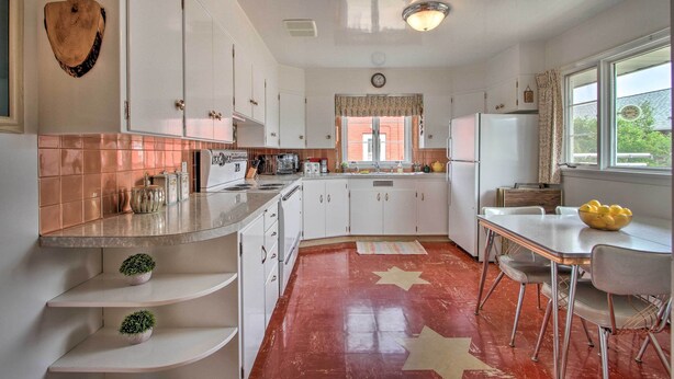A kitchen with white cabinets, a countertop, a sink, and a dining table with chairs. - Nostalgic & Retro Anaconda Home, Walk to Town (Anaconda)