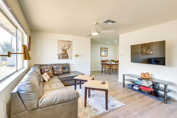 A living room with a sofa, coffee table, and TV. - Kingman Vacation Rental w/ Yard + Fire Pit (Kingman)